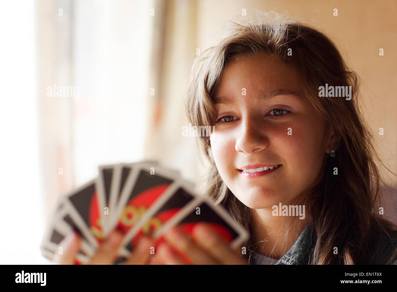 Teen  girl, 13-years old,  plays a game of Uno in the camp. A card game originally developed in 1971 by Merle Robbins Stock Photo
