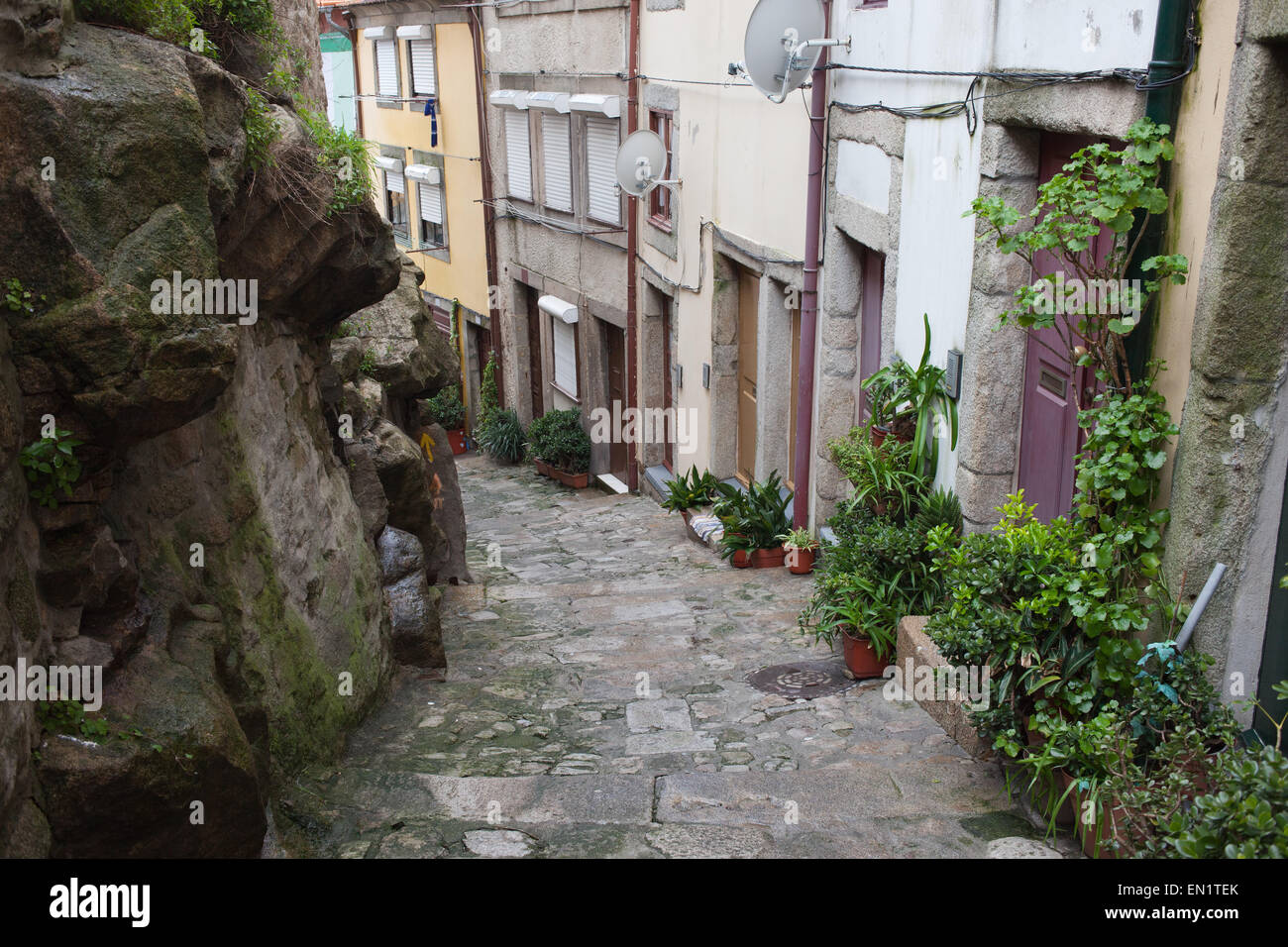 Traditional houses along descending narrow alley in the old town of Porto in Portugal. Stock Photo