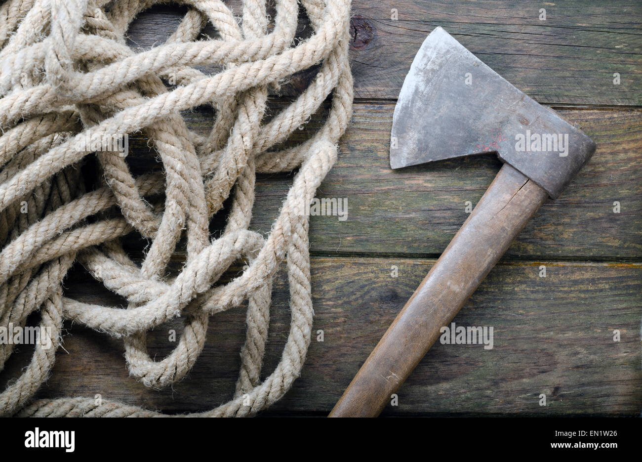 An old ax and a rope on a wooden table Stock Photo
