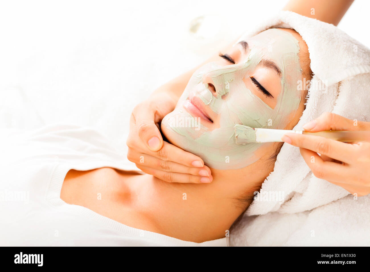 Young beautiful woman with clay facial mask Stock Photo