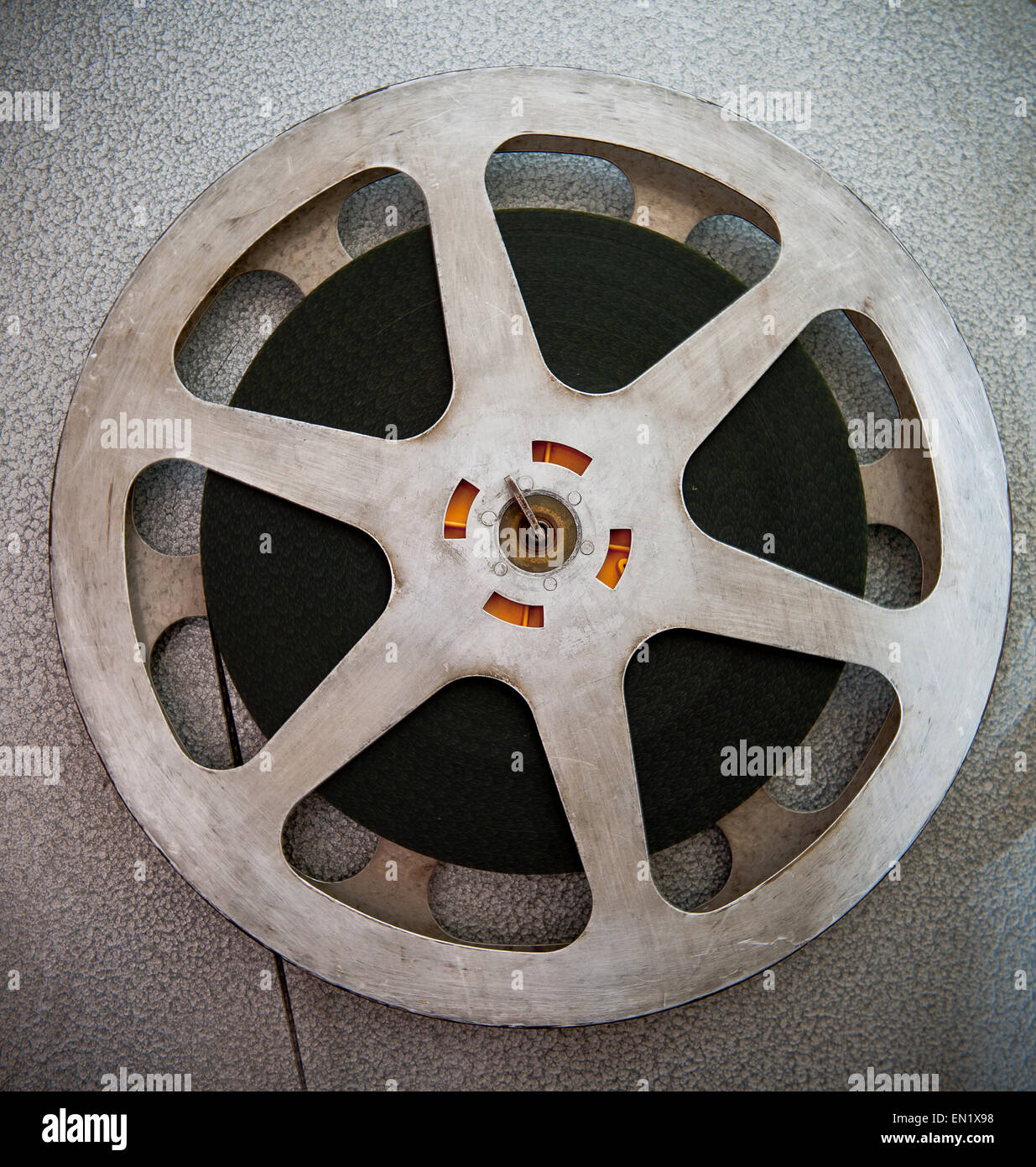 Old 8mm film projector playing in the night in dark room. Rotation reel  with tape on the video, audio tape recorder or player. Close-up of a reel  with a film Stock Photo 