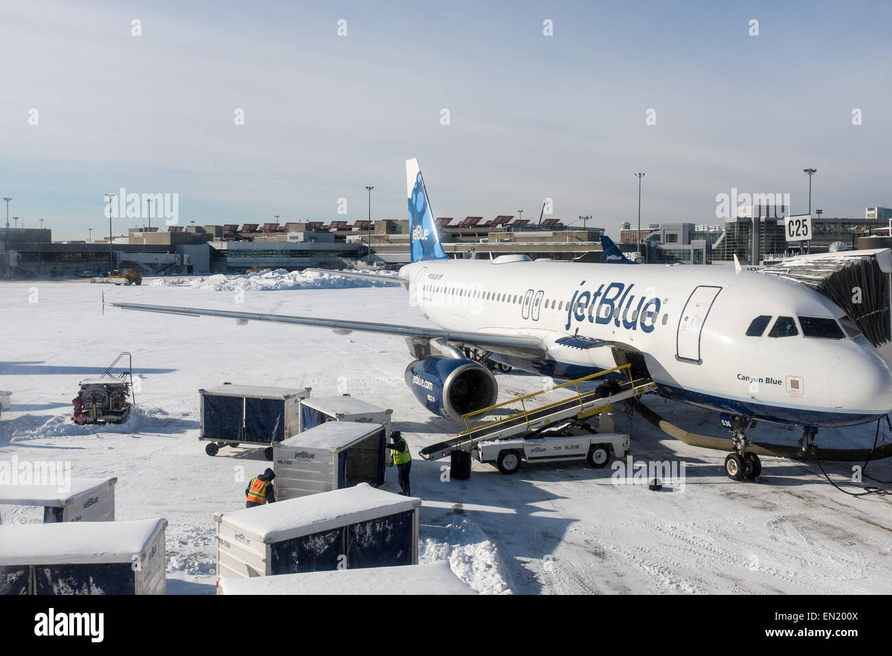 Jet blue airplane being prepared for flight at logan international airport Massachusetts usa with deep snow Stock Photo