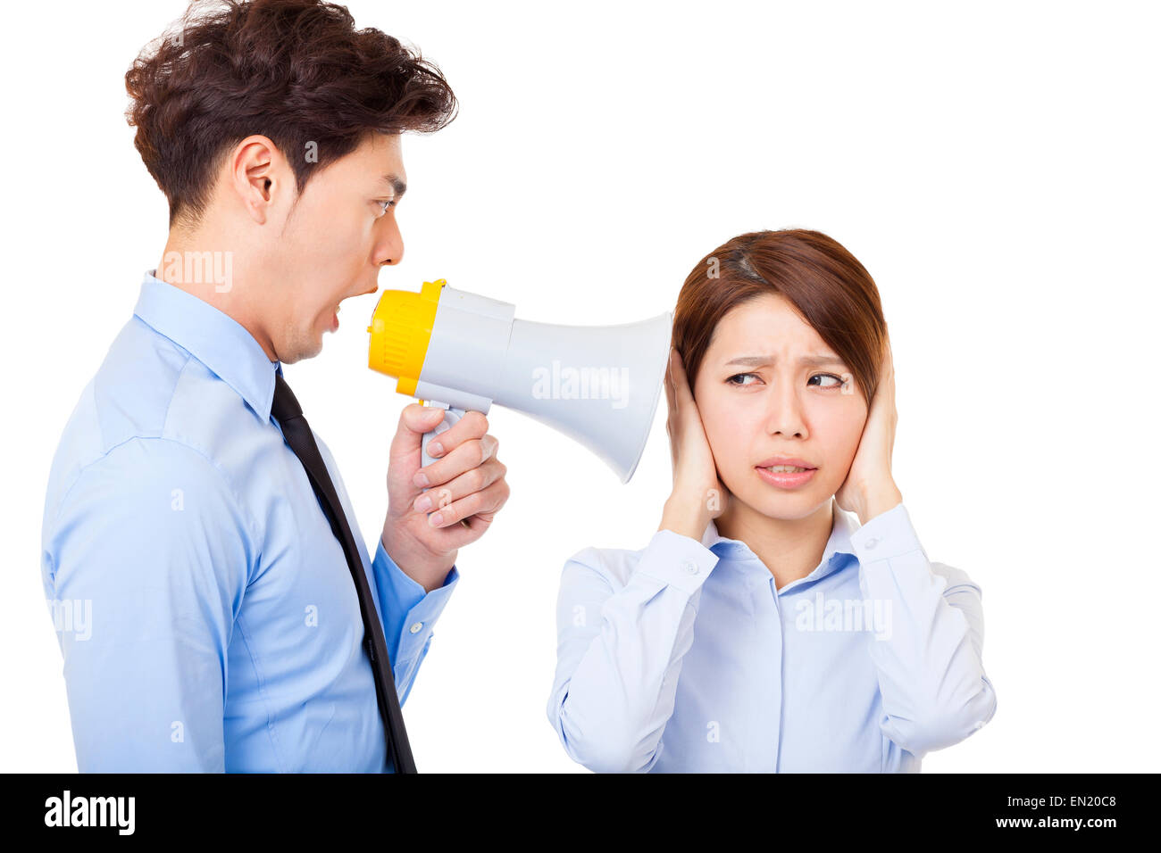 Businessman using megaphone to scream at businesswoman Stock Photo