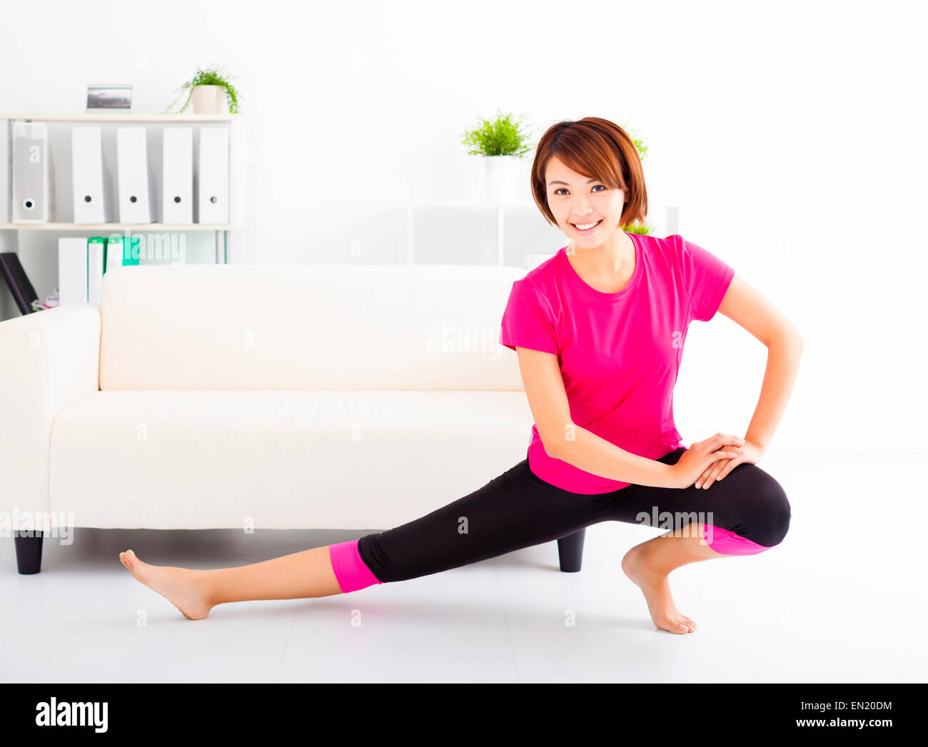beautiful young woman stretching on the floor Stock Photo - Alamy