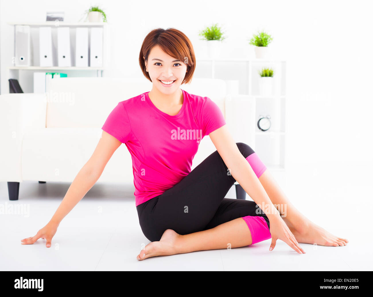 beautiful young woman stretching on the floor Stock Photo