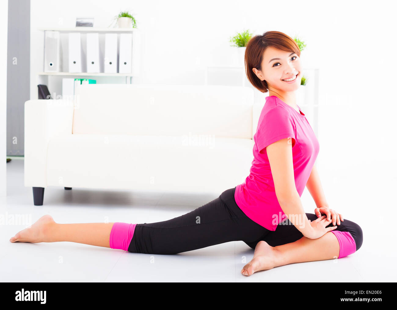 beautiful young woman stretching on the floor Stock Photo