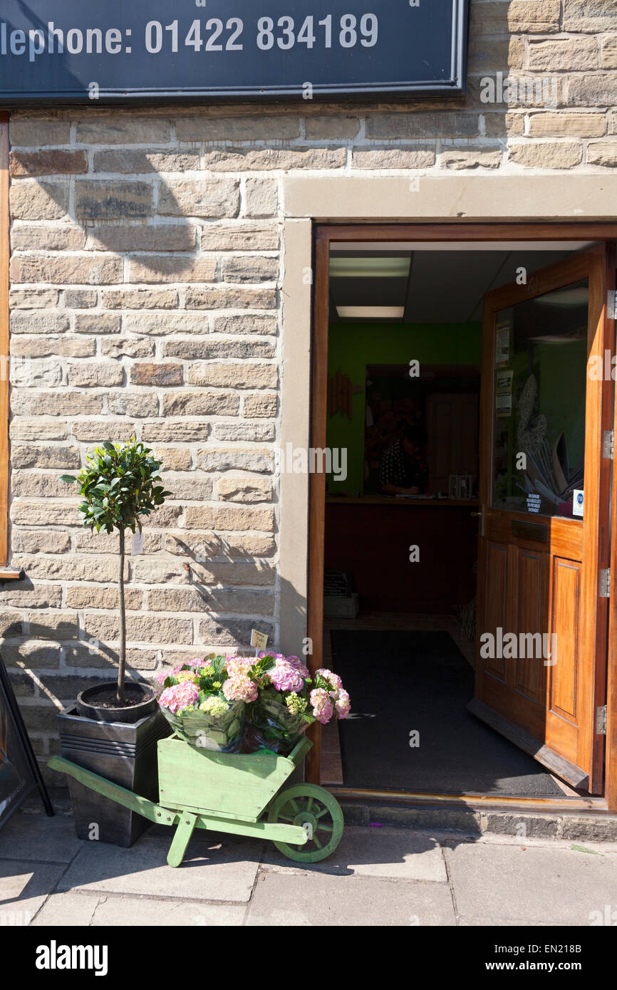 Flower display in wooden wheelbarrow outside A Little Bit of Eden, Sowerby Bridge, West