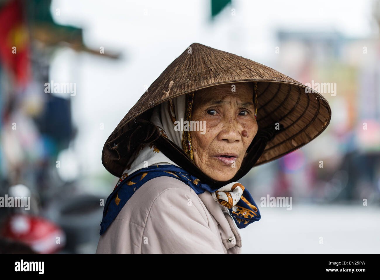 An Elderly Woman Wearing Traditional Conical Hat Stock Photo
