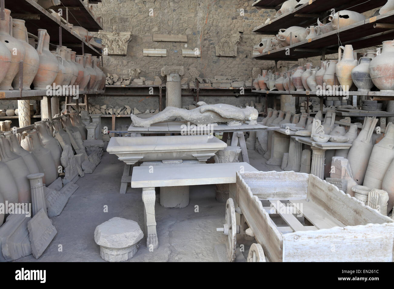 Supine body plaster cast, amphora and other archaeological material in the Granary, Pompeii, Italy. Stock Photo