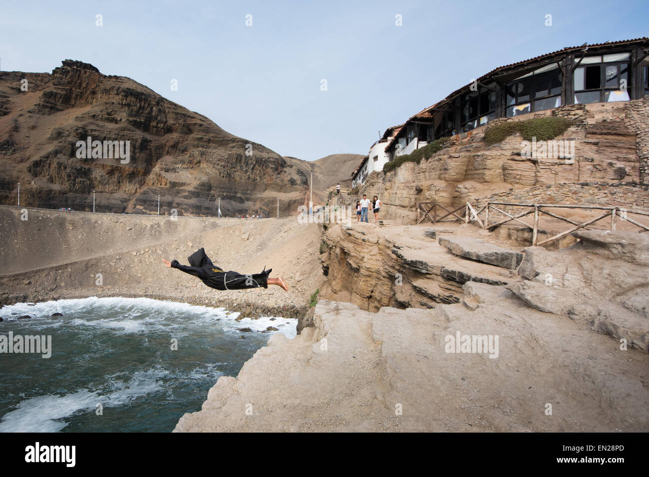 The 'diving monk' dives from the cliffs at the famous El Salto del Fraile restaurant in Chorrillos, Lima, Peru Stock Photo