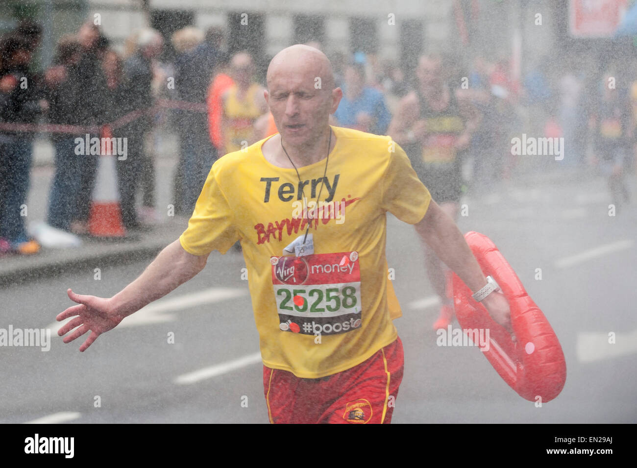 London, UK. 26 April 2015. A runner passes by a roadside shower with two miles to go as nearly 38,000 runners took part in the Virgin Money London Marathon. Credit:  Stephen Chung / Alamy Live News Stock Photo