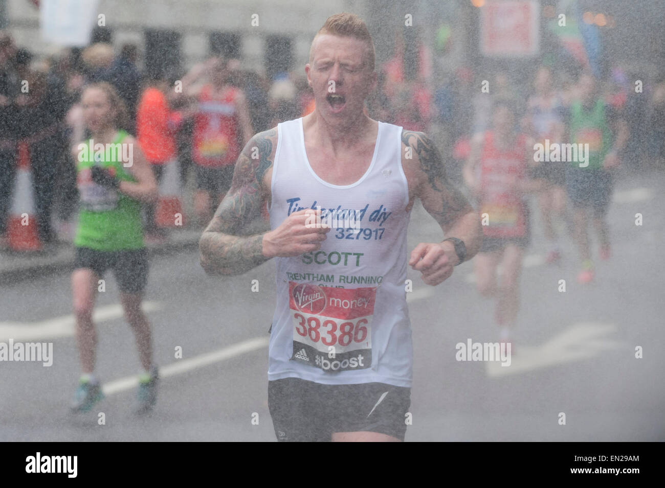 London, UK. 26 April 2015. A runner passes by a roadside shower with two miles to go as nearly 38,000 runners took part in the Virgin Money London Marathon. Credit:  Stephen Chung / Alamy Live News Stock Photo