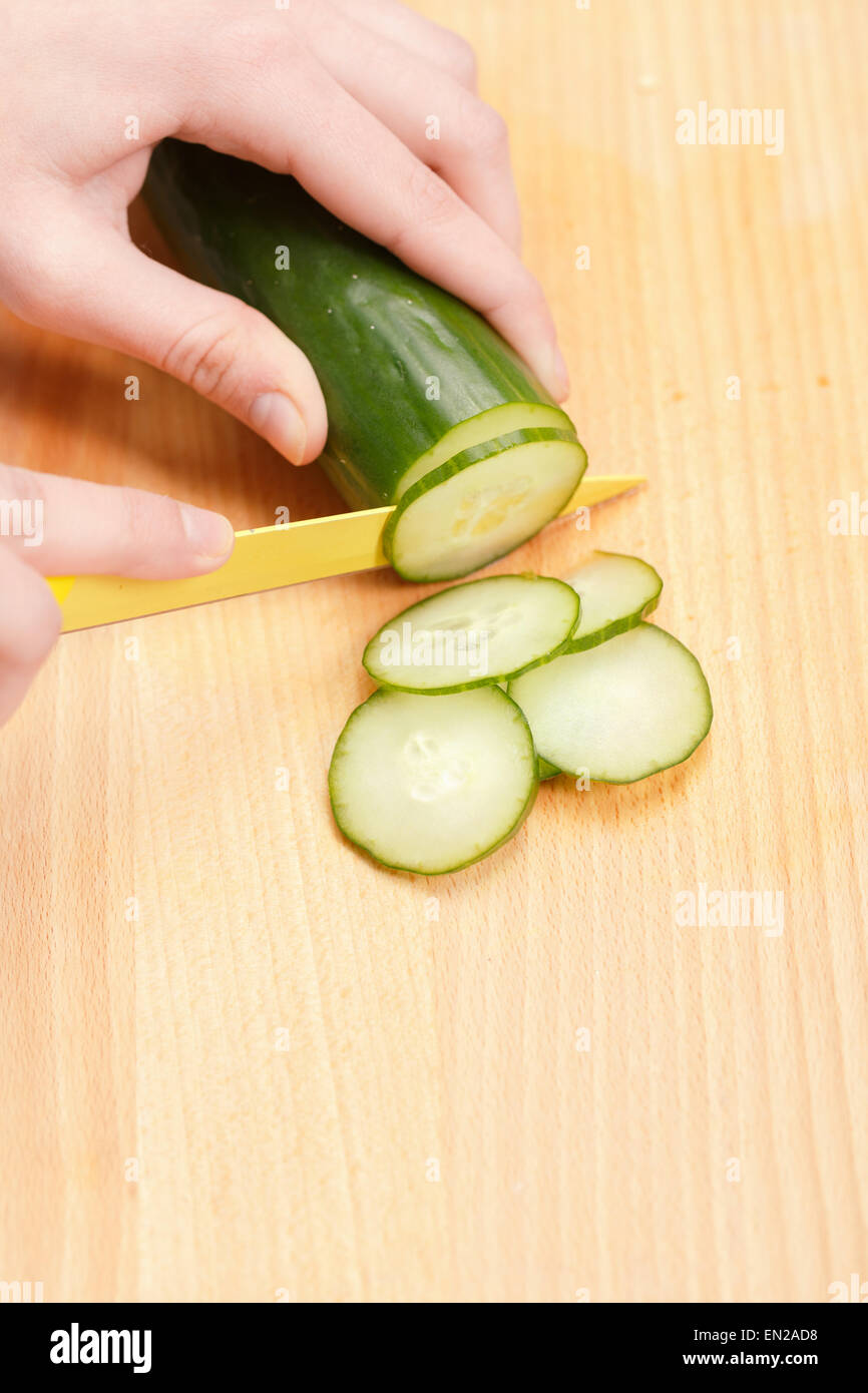 Hands cut cucumber on slicing board Stock Photo Alamy