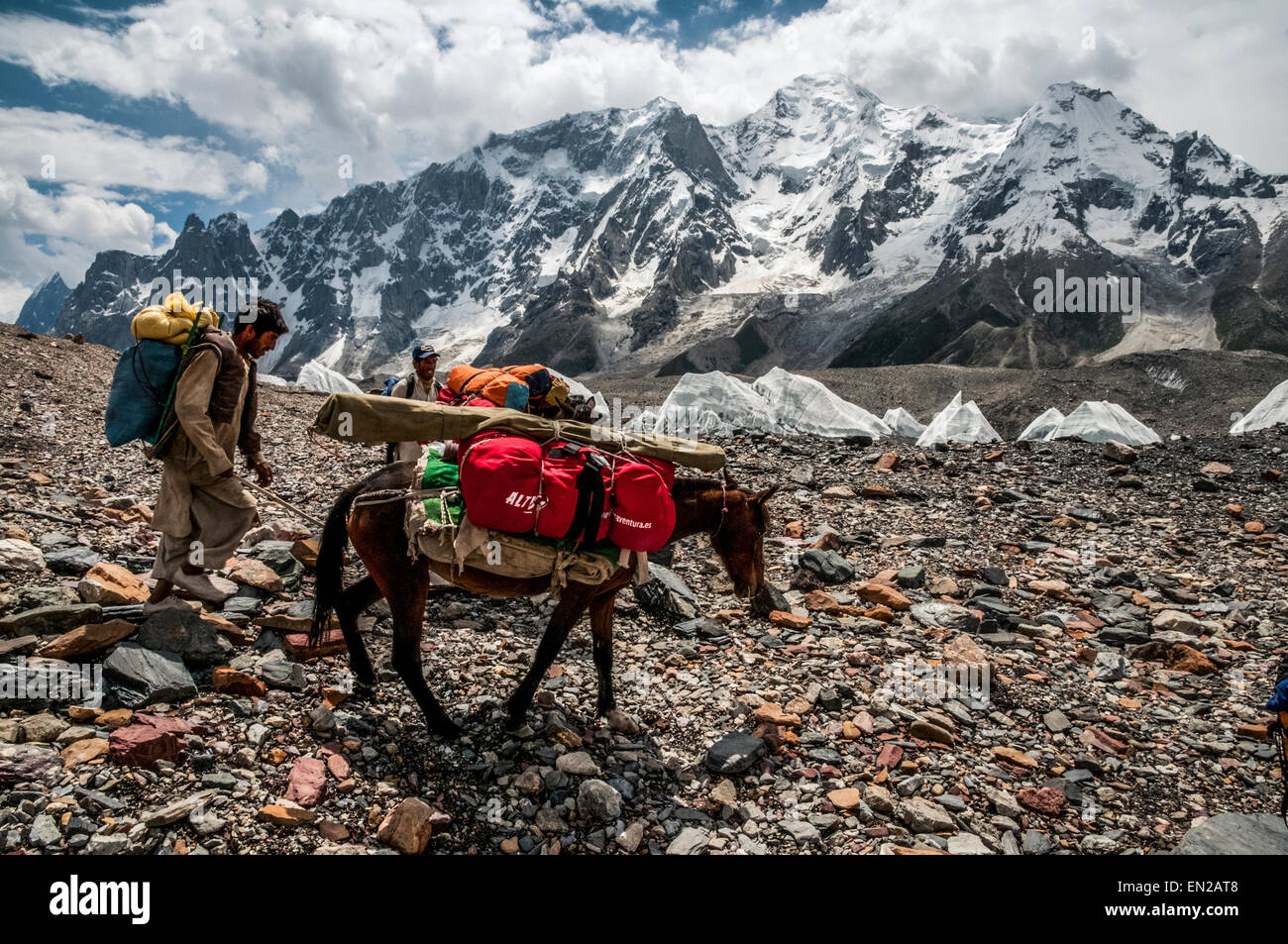 Trekking in the Karakoram Mountains Porter with pack horse and Masherbrum 7821m in the distance Stock Photo