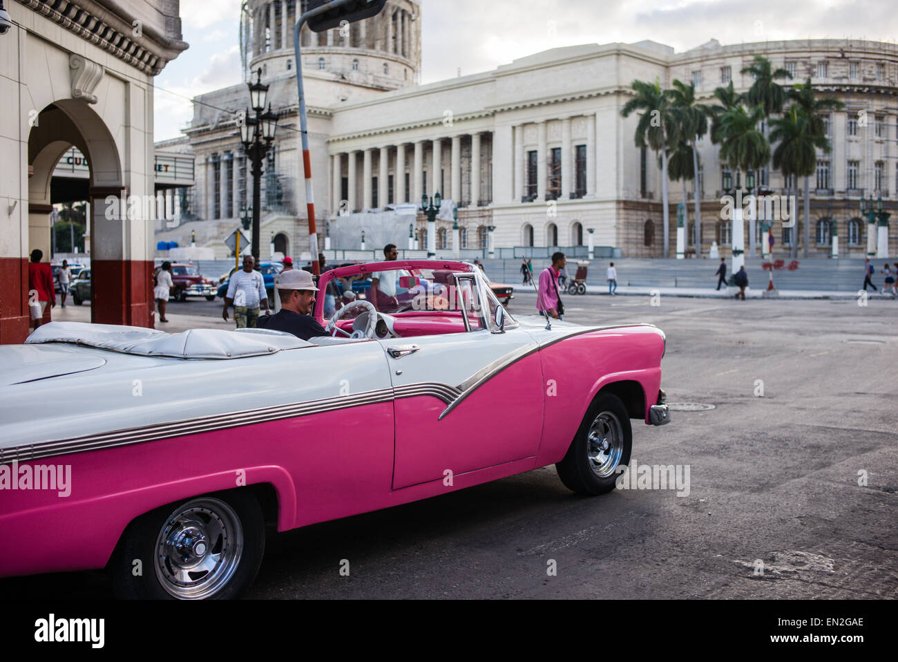 Vintage pink and white Ford convertible used as a taxi on the streets ...