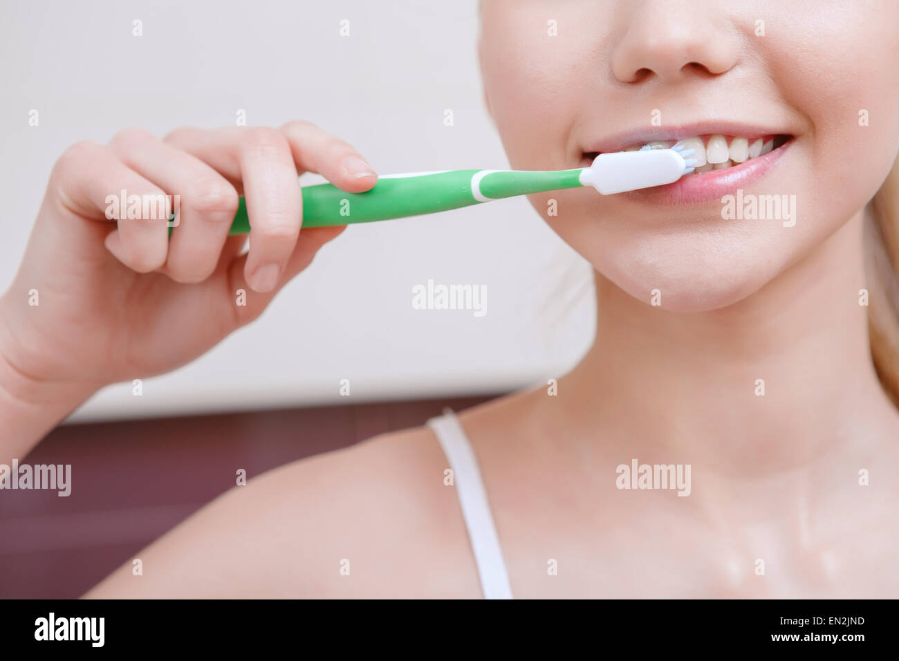 Pretty young woman cleaning her teeth Stock Photo