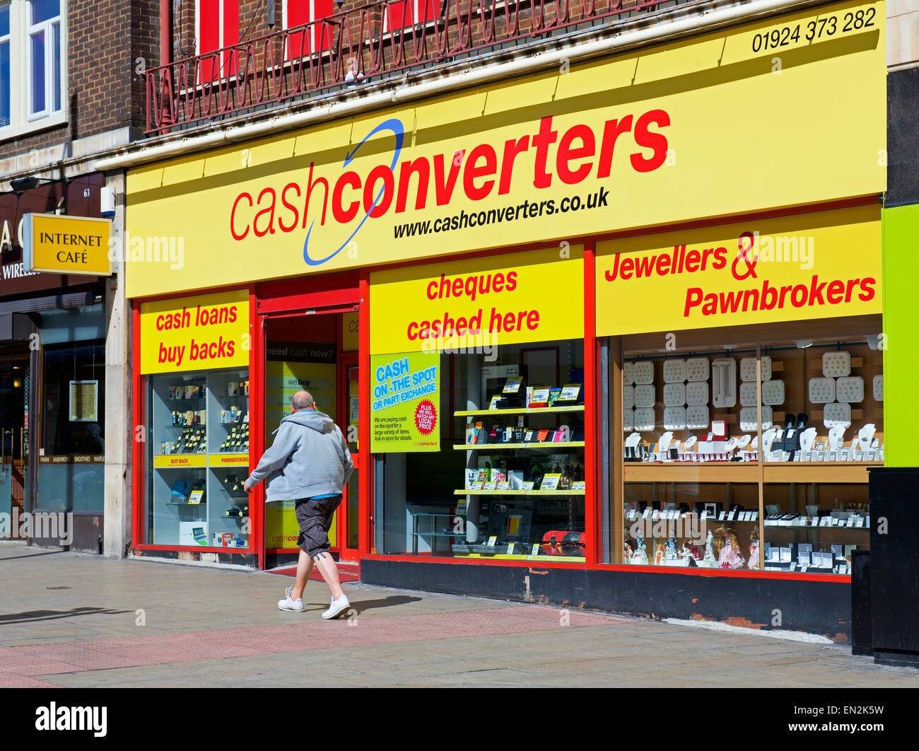 Man walking past branch of Cash Converters, England UK Stock Photo - Alamy