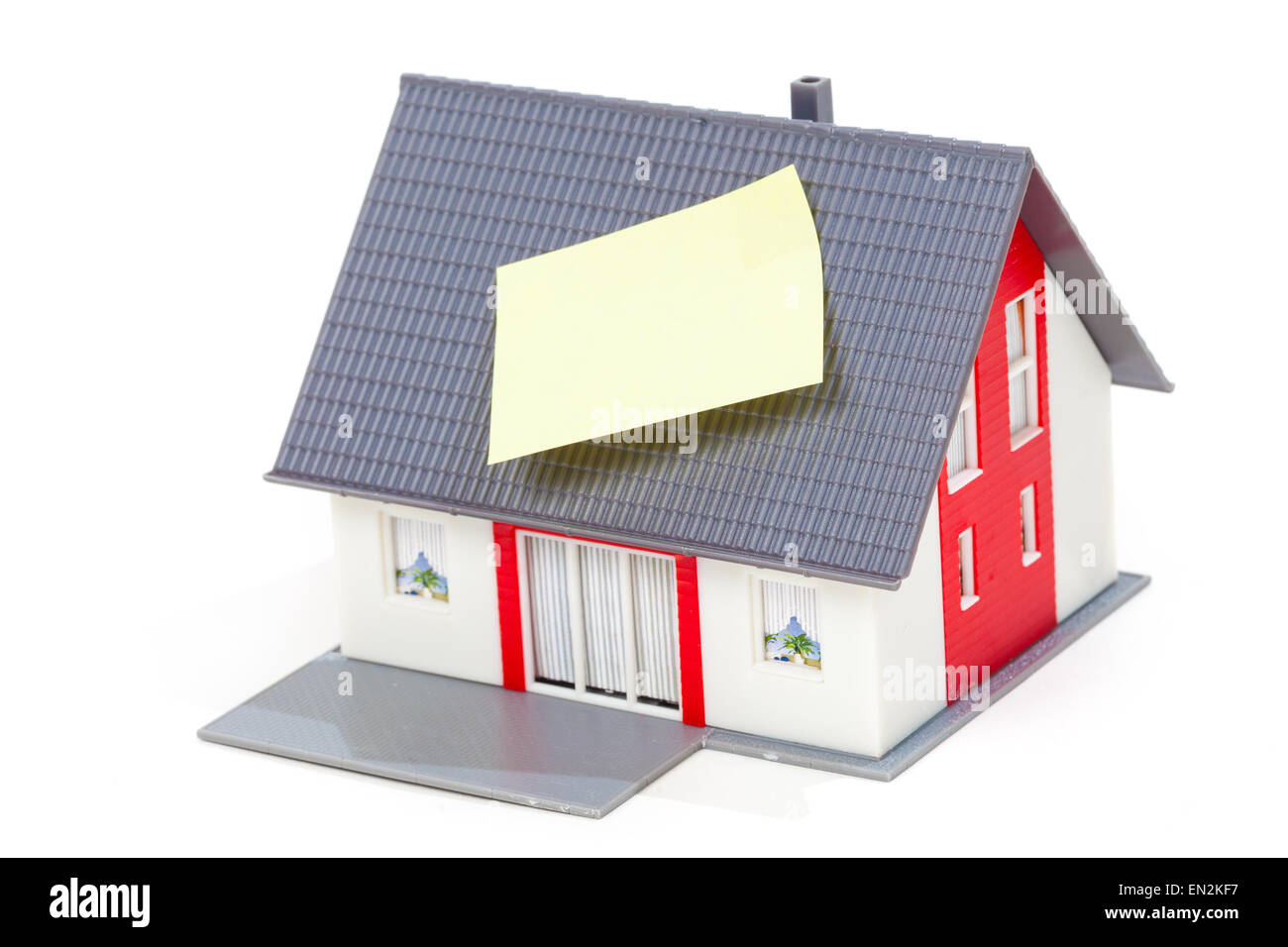 Nice model house with note on the roof isolated over white background Stock Photo