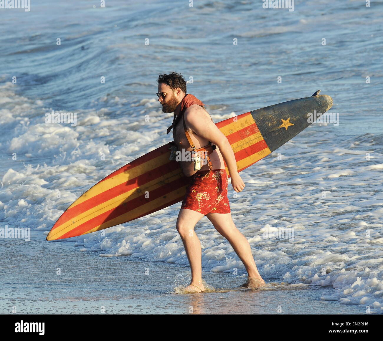Actor Seth Rogen is lock and loaded on the beach and ready to surf for the new movie 'Zeroville' filming in Malibu Ca. The comedian was seen holding a surf board and 2 guns in their holsters with swimming trunks while filming a sunset scene on the beach. The new movie is also produced and directed by his good pal James Franco.  Featuring: Seth Rogen Where: Malibu, California, United States When: 22 Oct 2014 Stock Photo