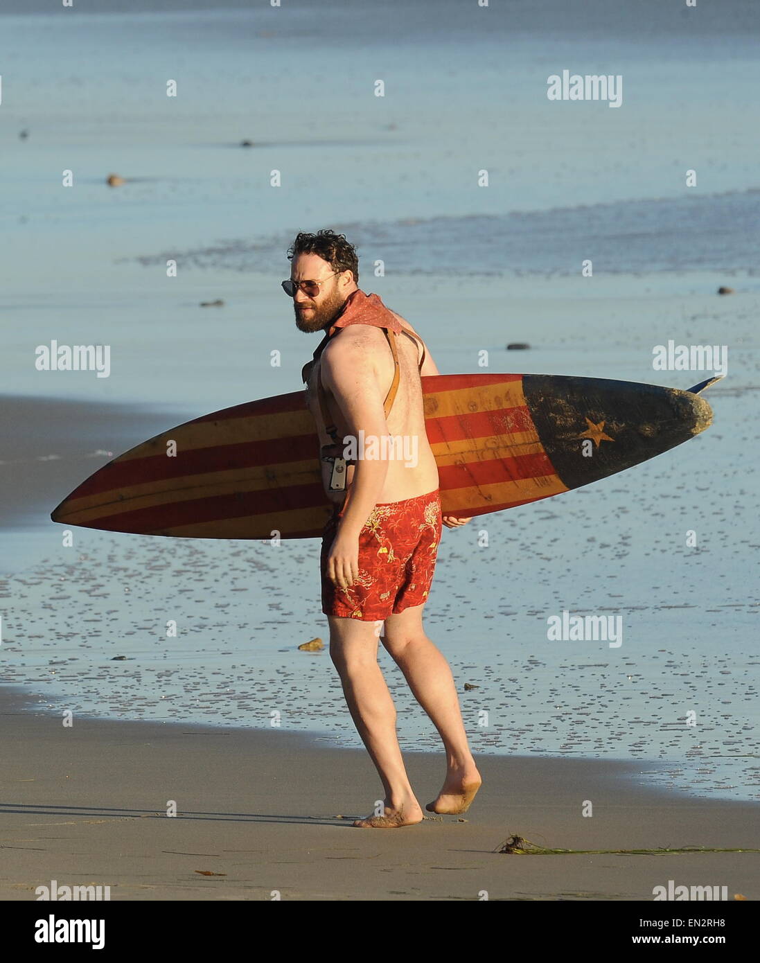 Actor Seth Rogen is lock and loaded on the beach and ready to surf for the new movie "Zeroville" filming in Malibu Ca. The comedian was seen holding a surf board and 2 guns in their holsters with swimming trunks while filming a sunset scene on the beach. The new movie is also produced and directed by his good pal James Franco.  Featuring: Seth Rogen Where: Malibu, California, United States When: 22 Oct 2014 Stock Photo