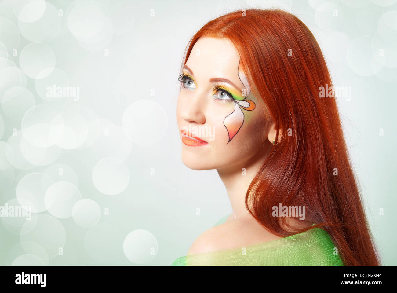 Portrait of red-haired girl with flower painted on his face Stock Photo