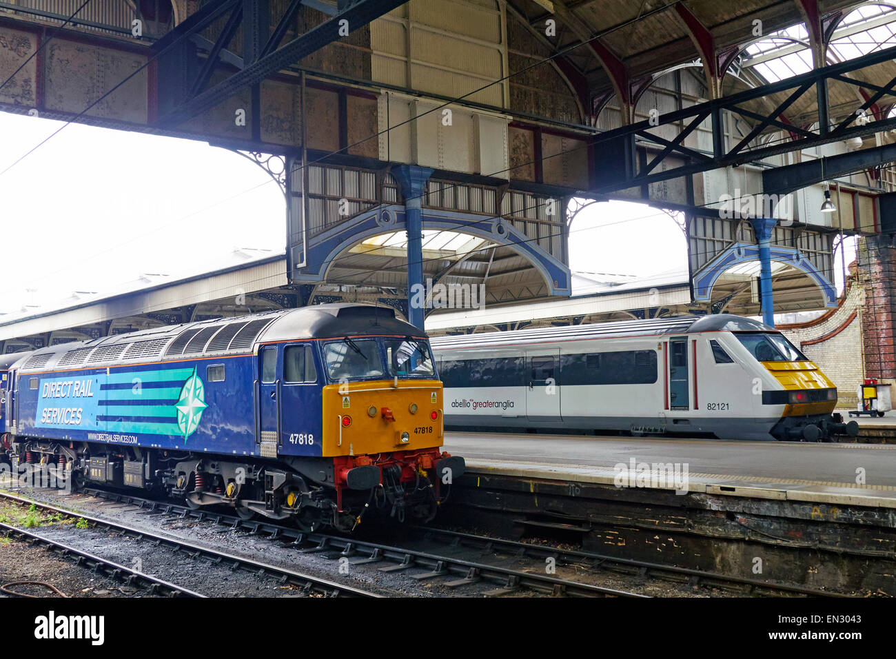Direct Rail Services Class 47 diesel locomotive standing at Norwich Station , Abellio Greater Anglia electric at next platform. Stock Photo