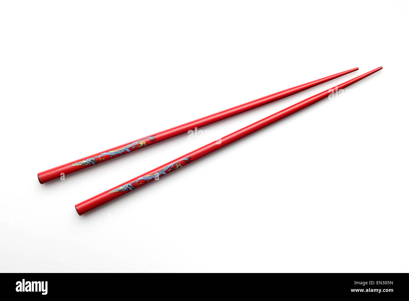 High resolution image of red wooden chopsticks with blue and yellow dragon. Stock Photo