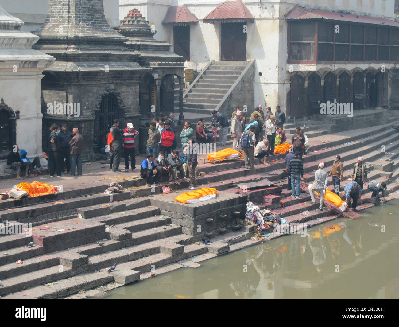 Earthquake Kathmandu Nepal dead bodies on funeral pyres on edge of Bagmati River receiving final Rites Stock Photo