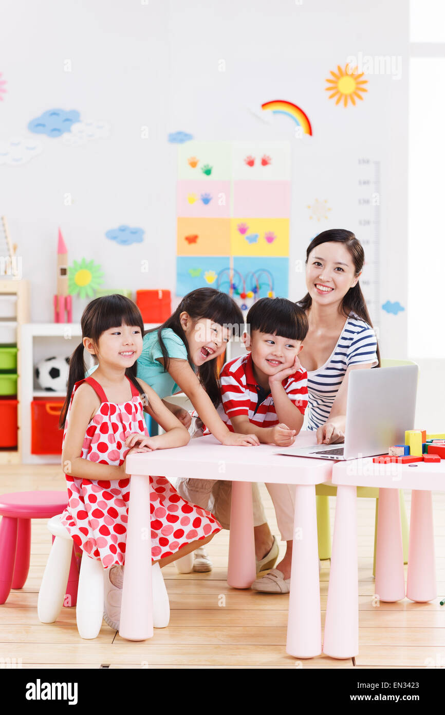 The teacher and children to use the computer in the kindergarten Stock ...
