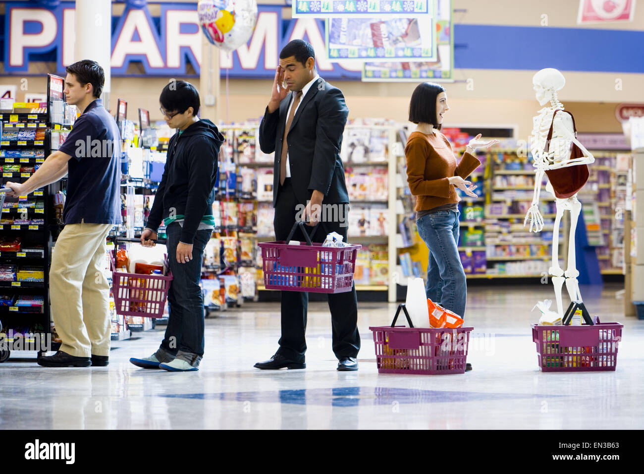 Four people and a skeleton in grocery store lineup Stock Photo