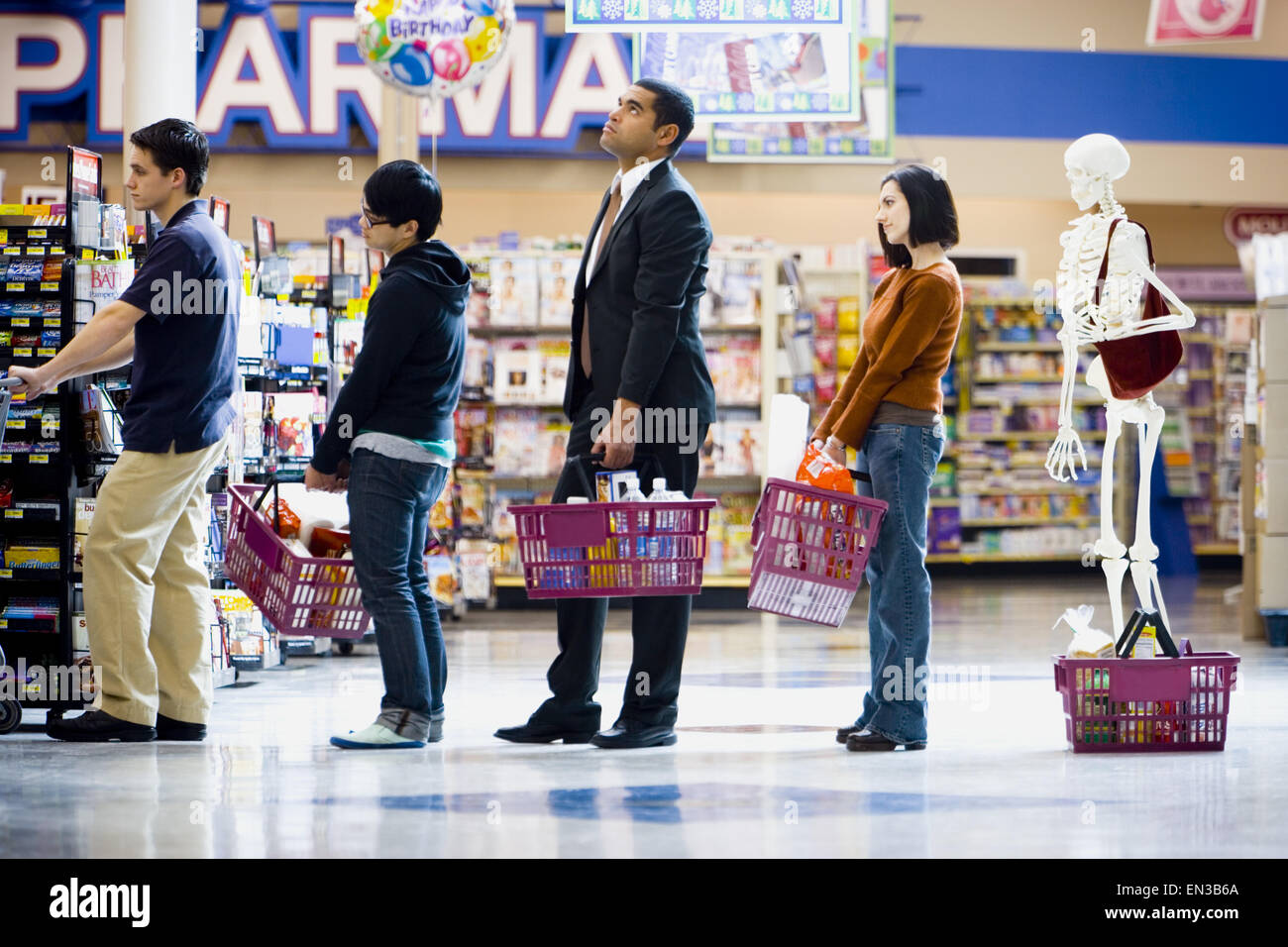 Four people and a skeleton in grocery store lineup Stock Photo