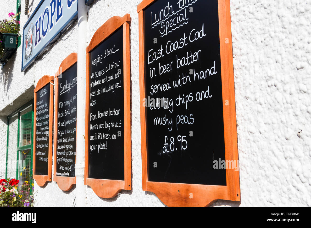 Restaurant food information and menu blackboards on the exterior wall of the Hope and Anchor hotel, Alnmouth, Northumberland. Stock Photo