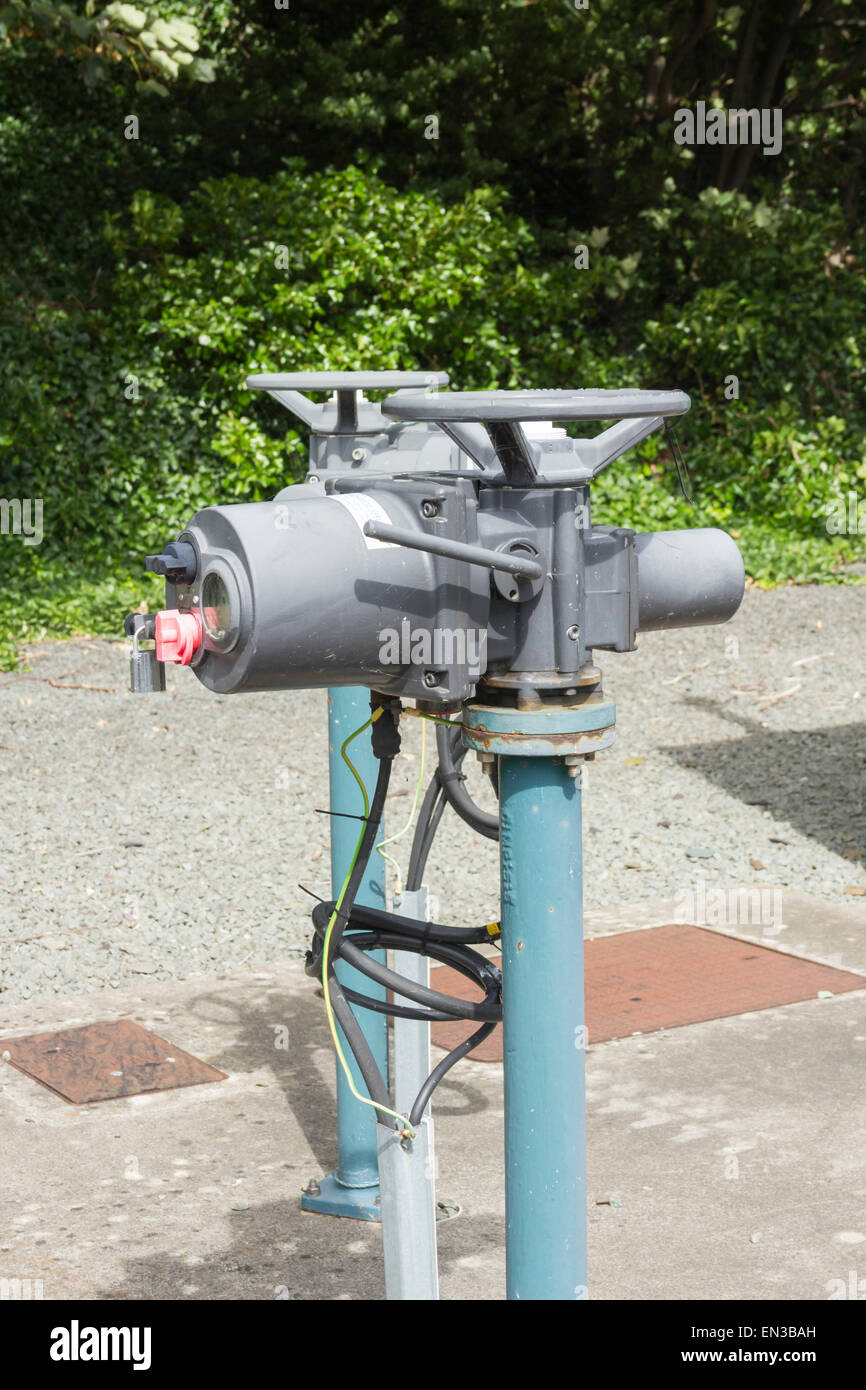 Electric control mechanisms installed on pipe valve controls at a sewage pumping station near the river estuary in Conwy. Stock Photo