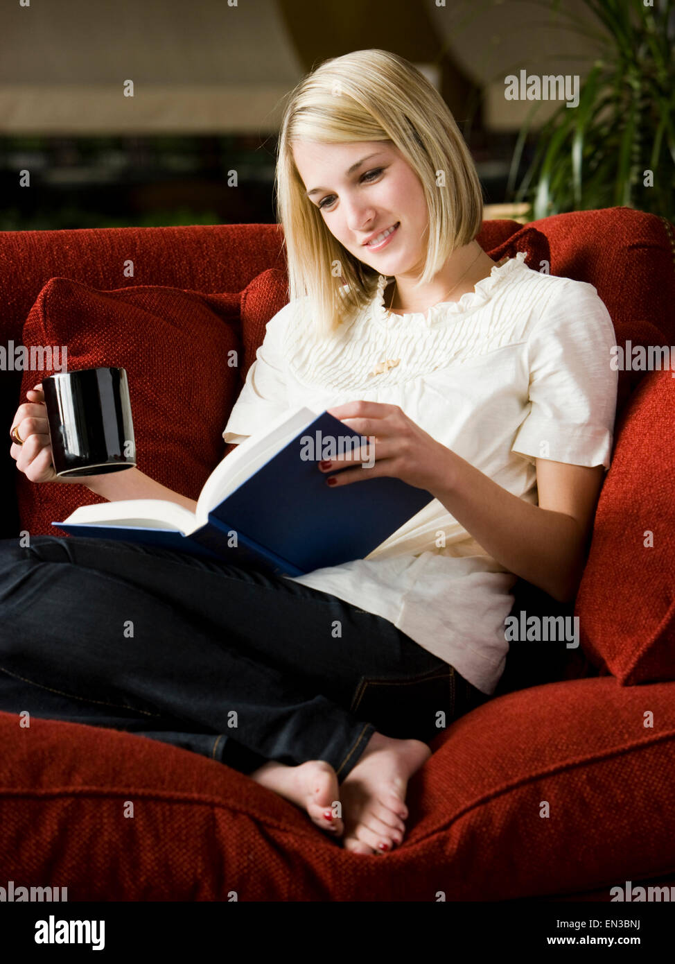 woman reading on the couch Stock Photo