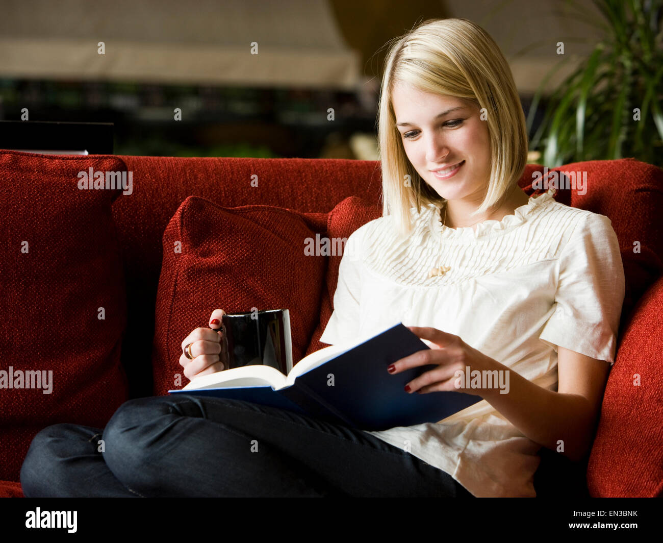 woman reading on the couch Stock Photo