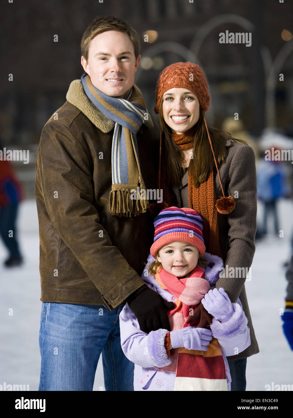 Man and woman with little girl outdoors in winter Stock Photo