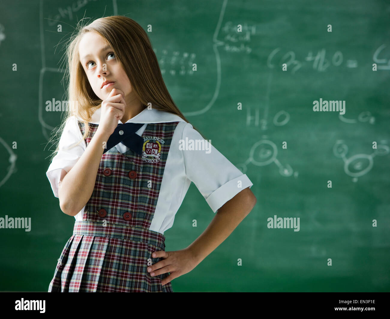 girl in a classroom standing in front of the chalkboard Stock Photo