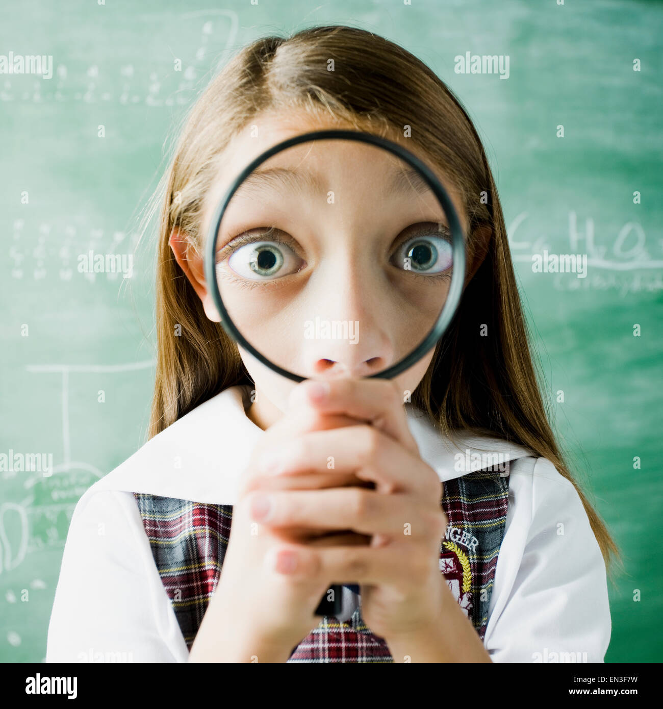 girl in a classroom smiling through a magnifying glass Stock Photo Alamy
