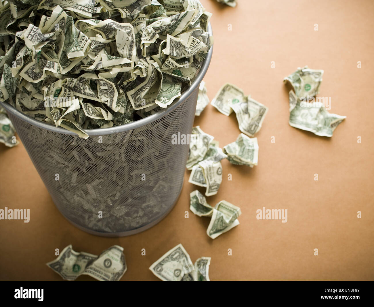 Waste paper basket with crumpled money Stock Photo