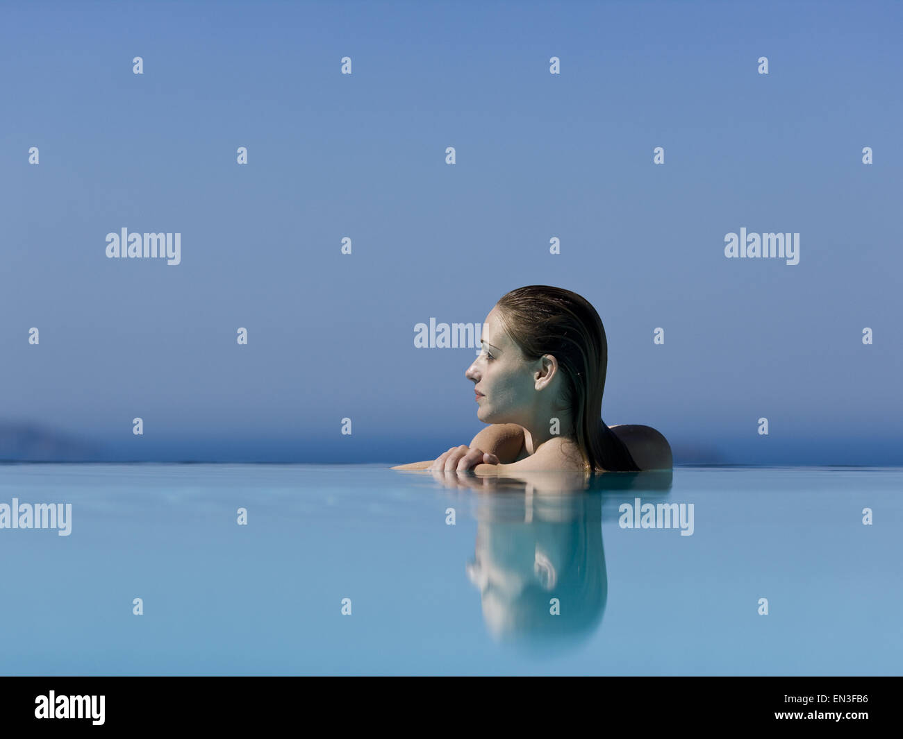 Woman in infinity pool reflection Stock Photo