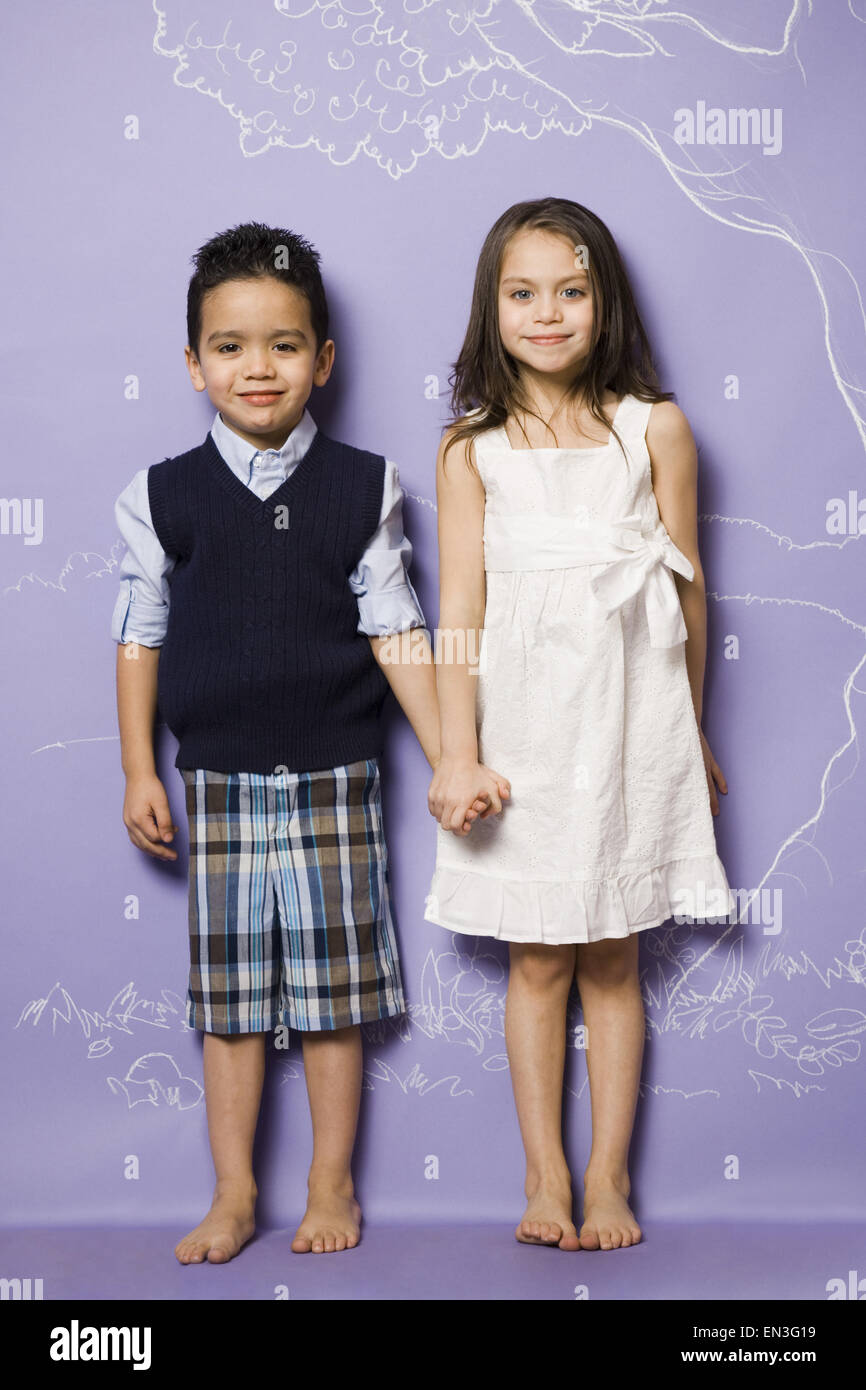 Young girl and boy holding hands smiling Stock Photo - Alamy
