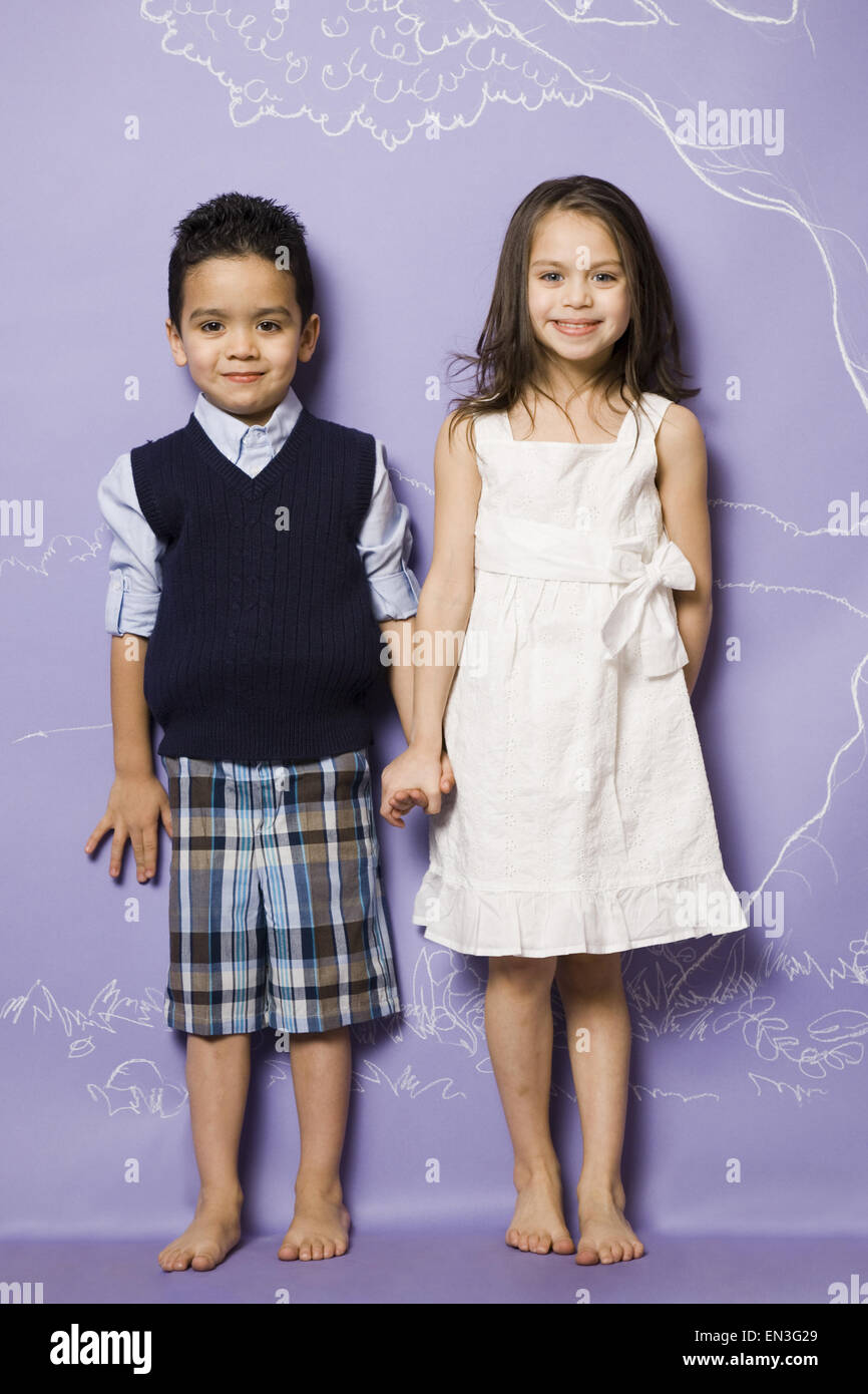Young girl and boy holding hands smiling Stock Photo - Alamy