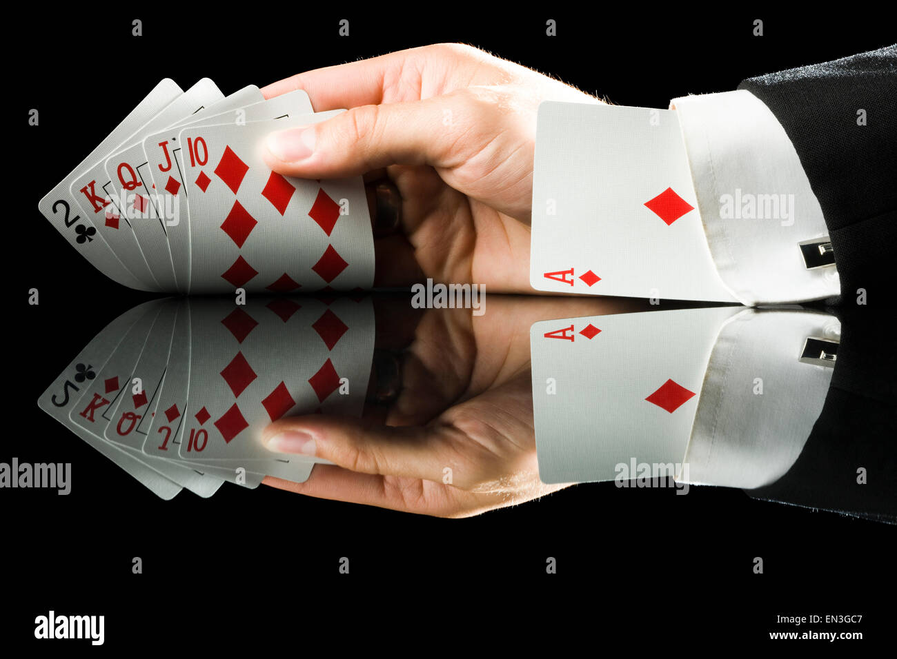 hand holding playing cards with an ace up his sleeve Stock Photo