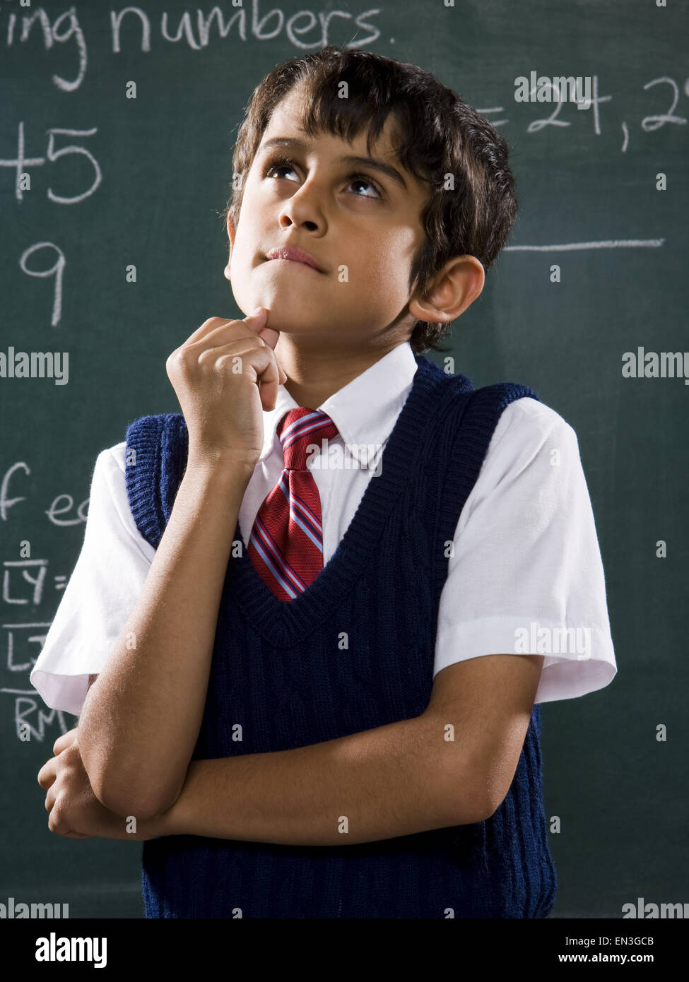Boy at chalkboard with math formulas thinking Stock Photo