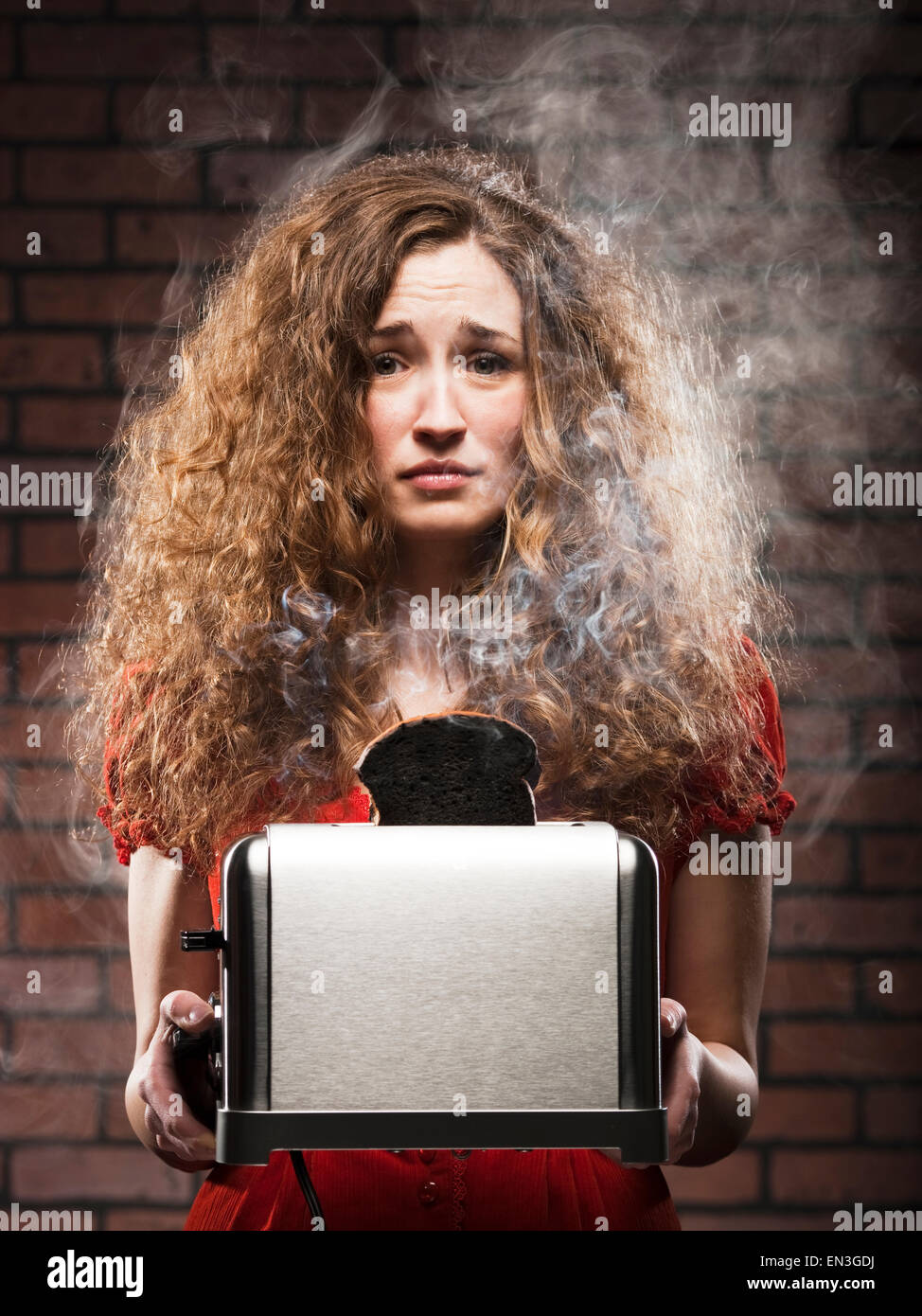 woman holding a toaster with a burnt piece of toast Stock Photo Alamy
