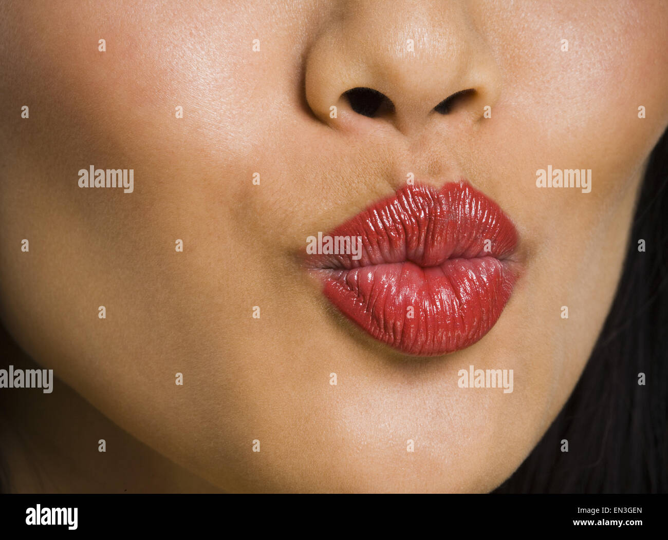 Closeup of female mouth with red lipstick puckering Stock Photo