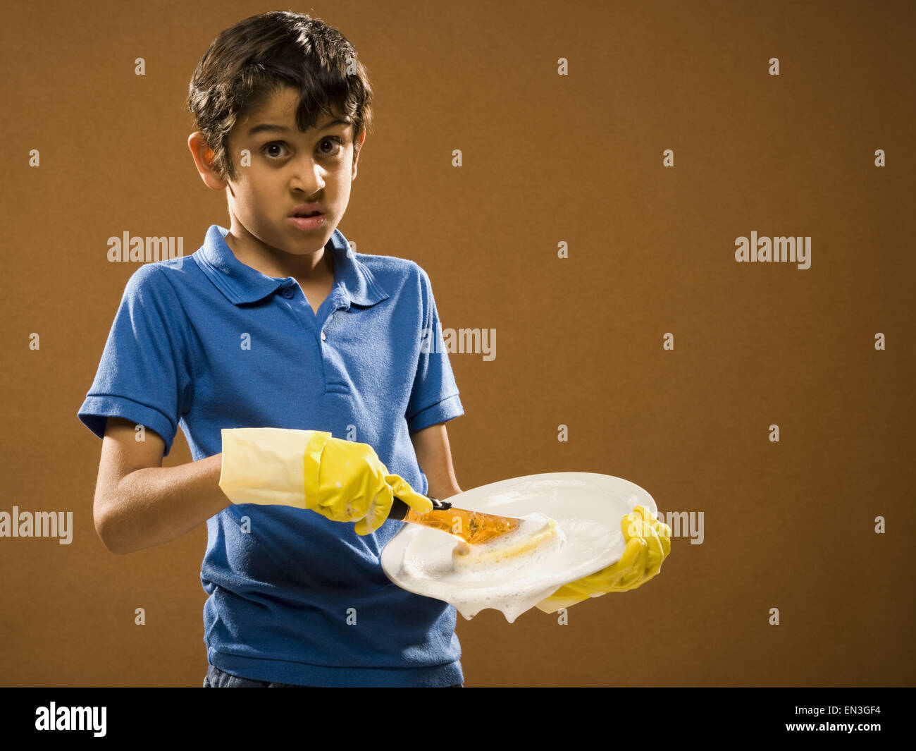 Boy with rubber gloves scrubbing plate Stock Photo Alamy