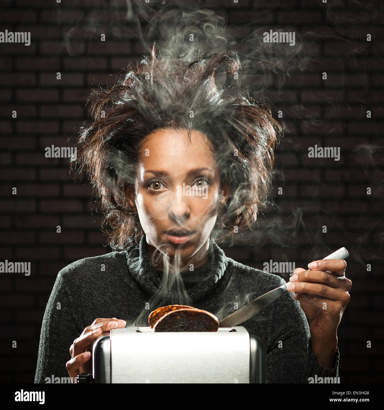 Studio shot of woman with smoking toaster Stock Photo