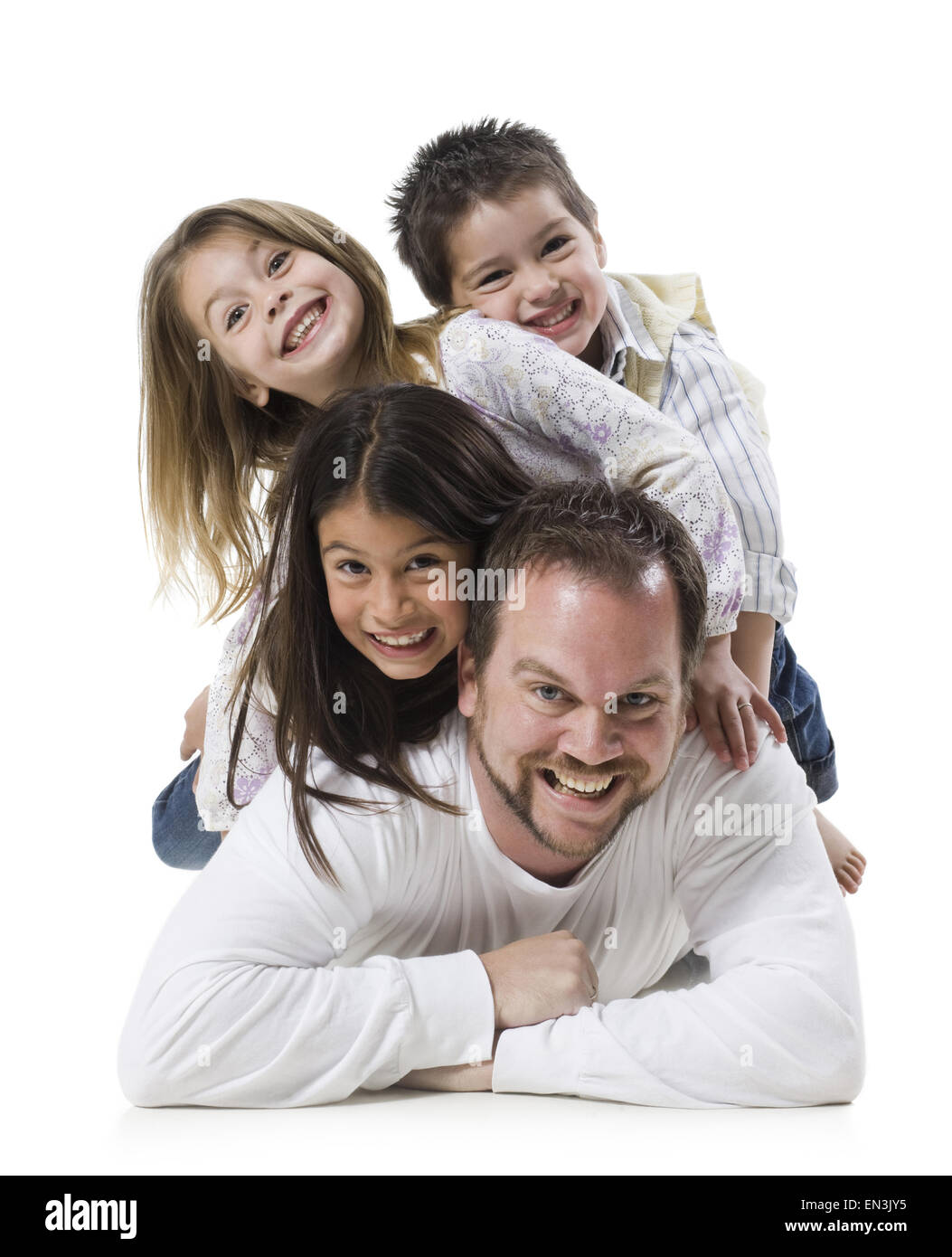 father and three children lying on top of each other Stock Photo