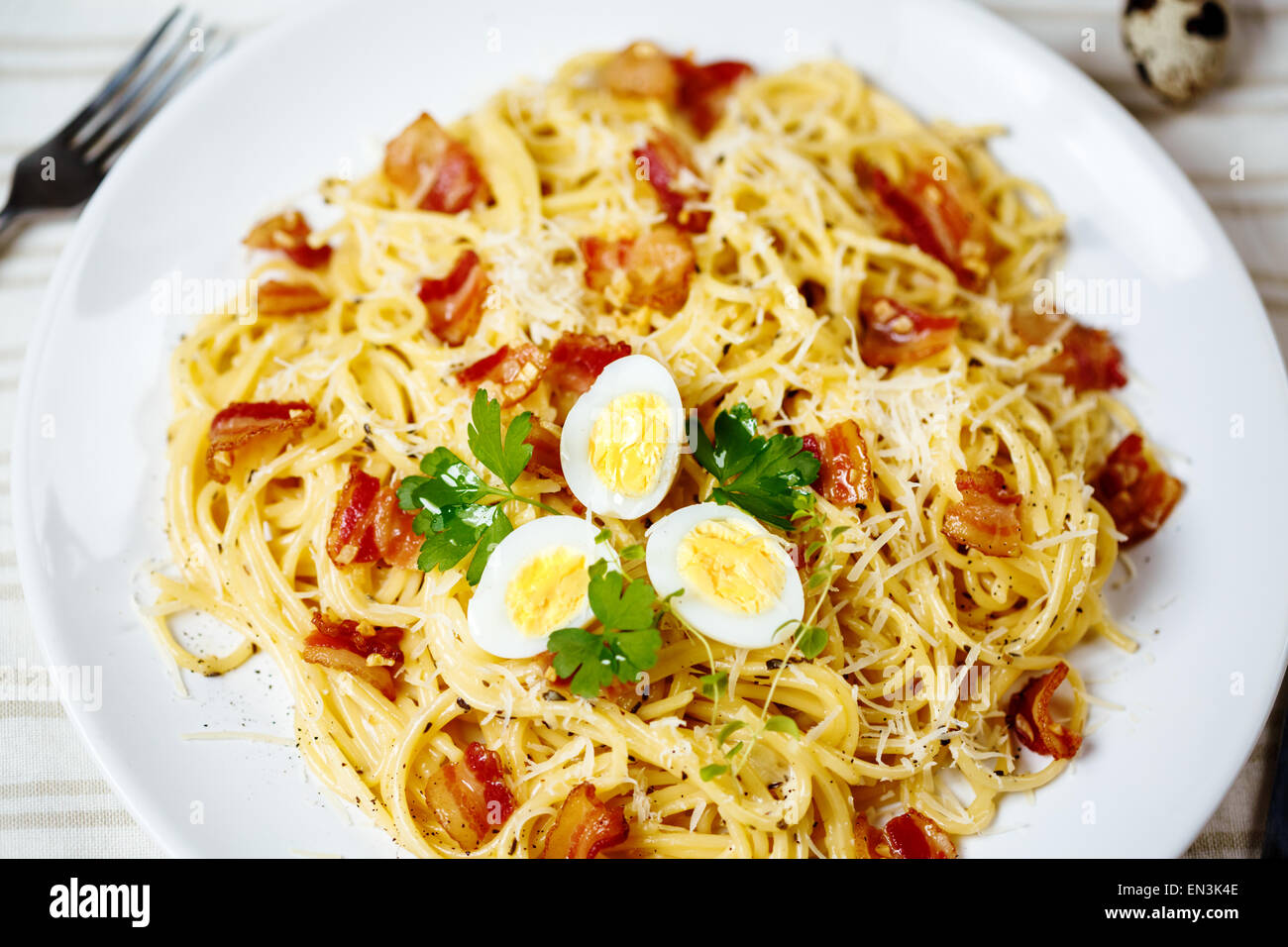 Pasta. Spaghetti with carbonara sauce, parmesan cheese, bacon and quail